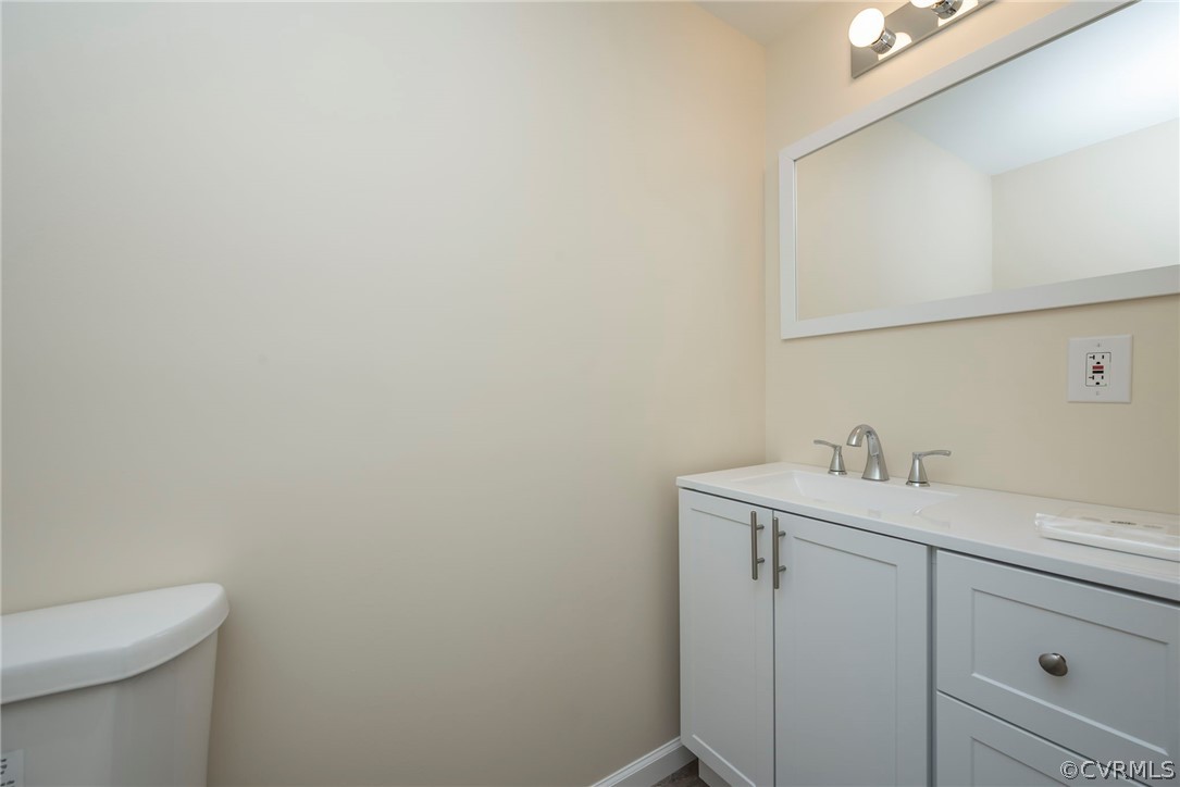 916 Nutbush Road Victoria, VA 23974 - Photo 16 of 25 a bathroom with a toilet a sink a vanity and mirror