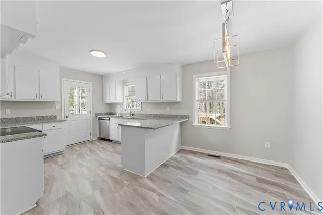 a kitchen with a white wooden cabinets sink and appliances