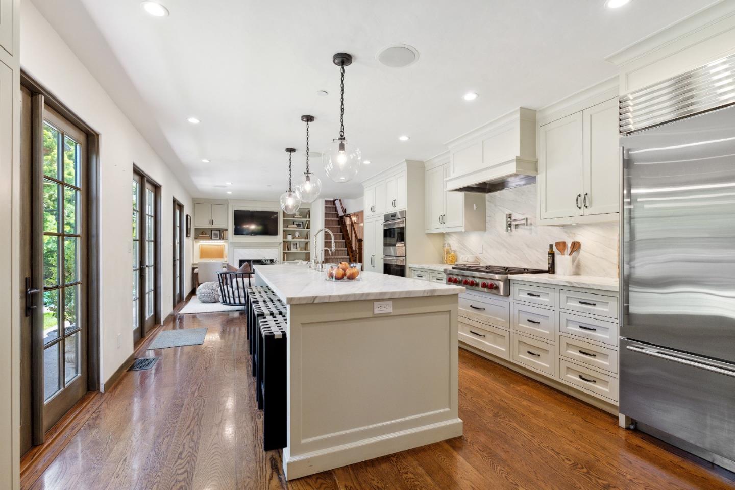540 Chelmsford Road Hillsborough, CA 94010 - Photo 15 of 49 a kitchen with stainless steel appliances kitchen island granite countertop a stove a refrigerator a oven and white cabinets with wooden floor