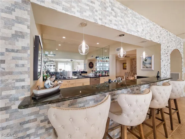 a living room with furniture a rug and kitchen view