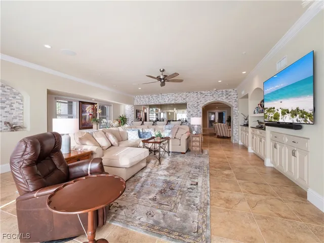 a bedroom with a bed couches and a flat tv screen