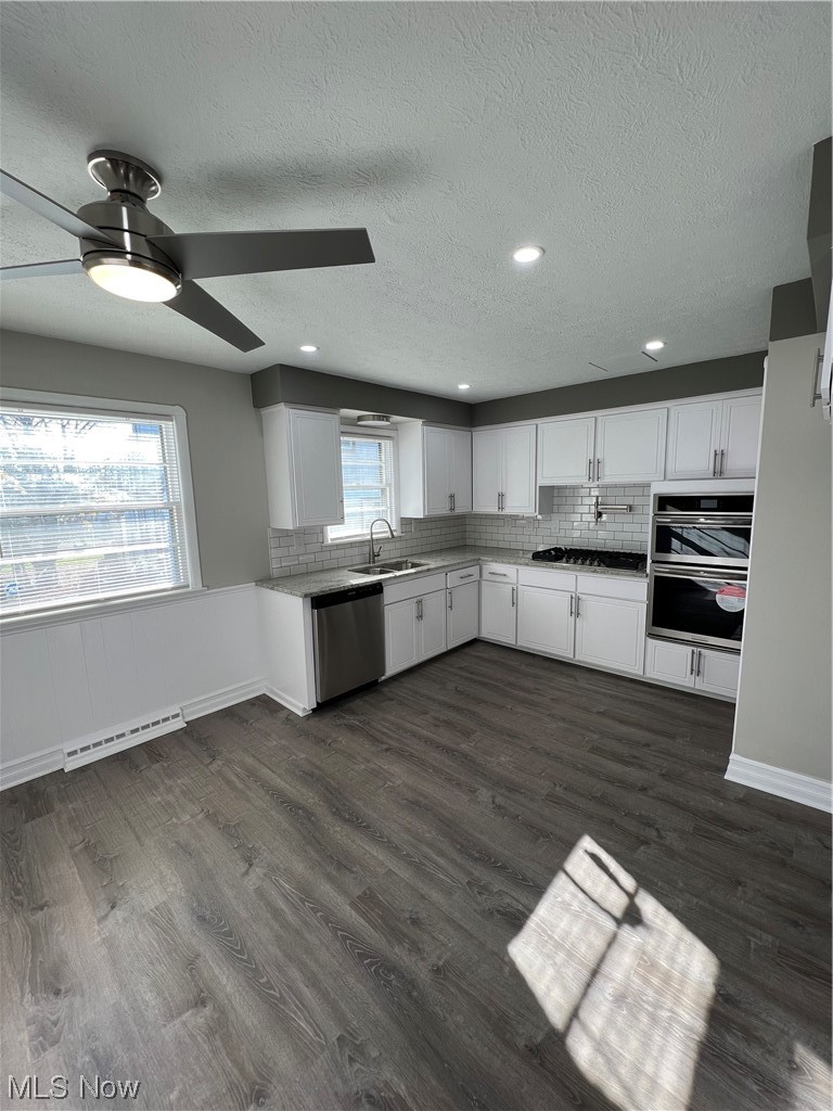 19306 Libby Road Maple Heights, OH 44137 - Photo 5 of 33 Kitchen with dark wood-type flooring, white cabinets, ceiling fan, and plenty of natural light