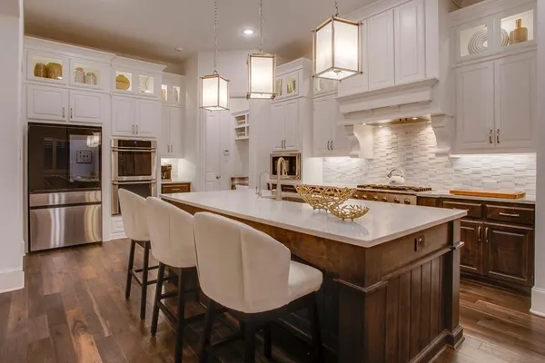 a kitchen with stainless steel appliances granite countertop a kitchen island a stove a table and chairs