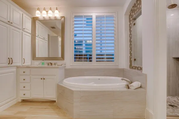 a bathroom with a tub sink and mirror