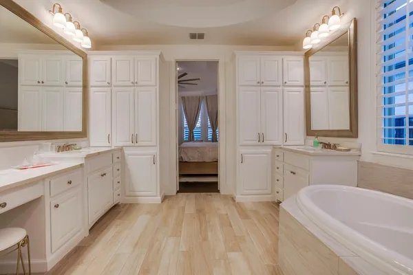 a bathroom with a tub sink and mirror