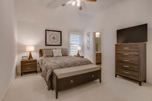 a spacious bedroom with a bed and a chandelier