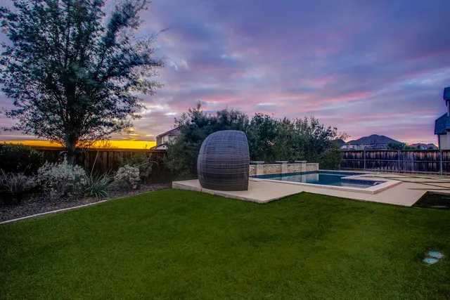 a view of a house with a swimming pool and a yard