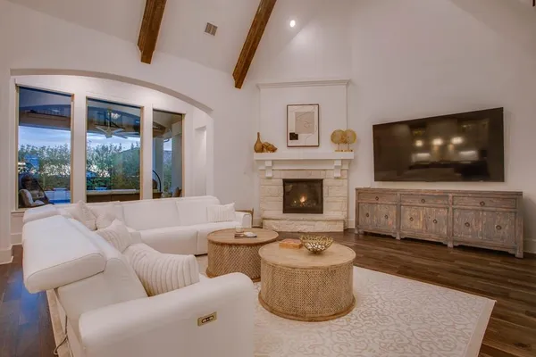 a living room with furniture a flat screen tv and a fireplace