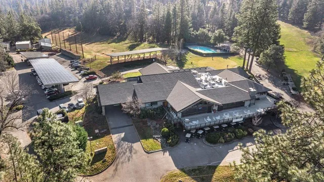 an aerial view of a house with swimming pool and outdoor seating