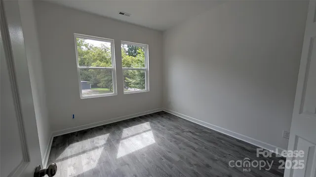 a view of a room with wooden floor and window