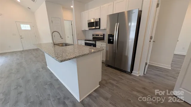 a kitchen with granite countertop a sink and a stove