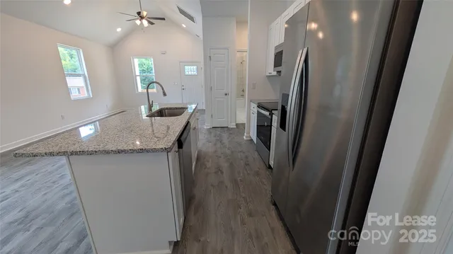 a view of a kitchen with a sink wooden floor and a large window