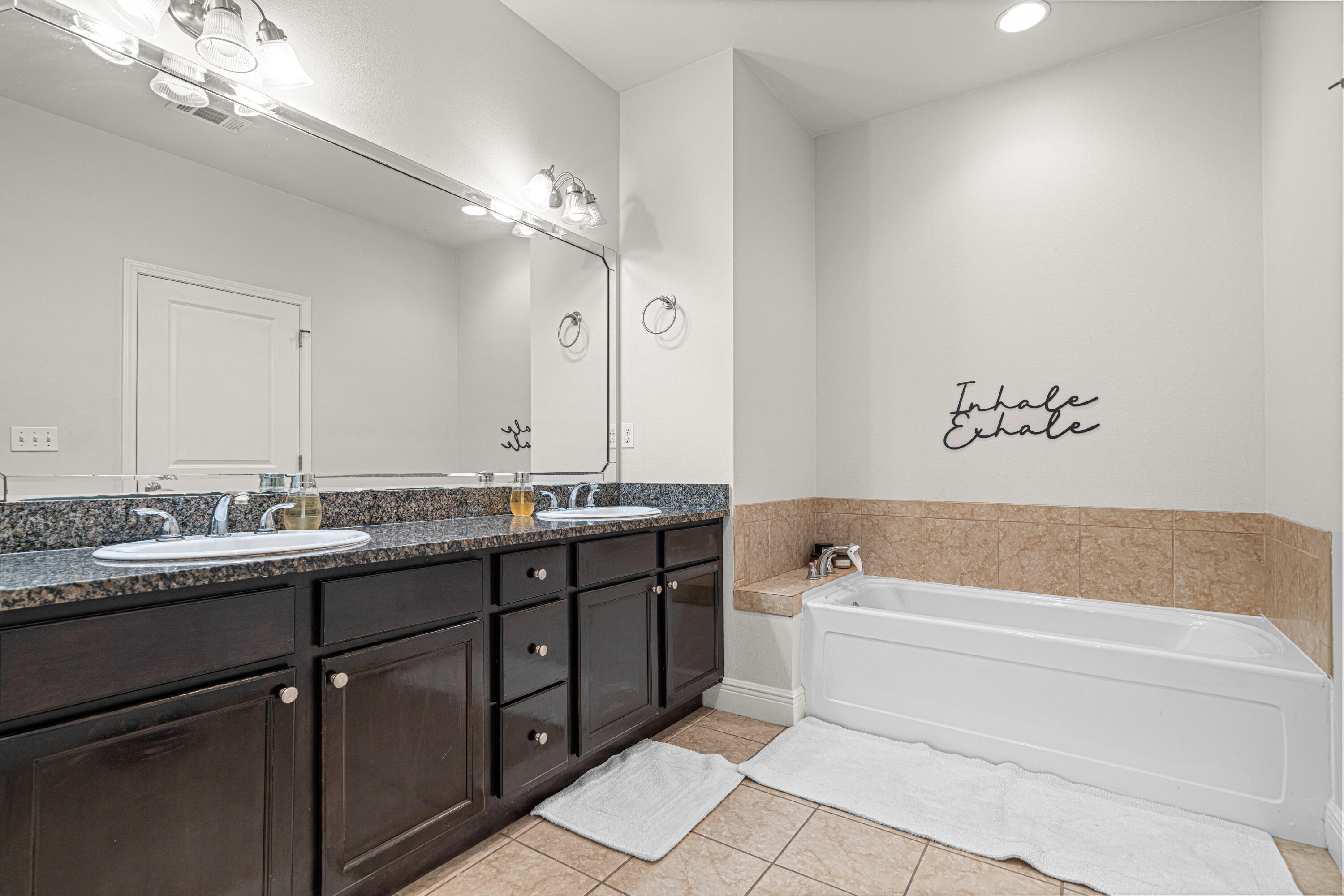 3263 Chapelwood Drive Crestview, FL 32539 - Photo 24 of 39 a bathroom with a tub a double vanity sink and a mirror