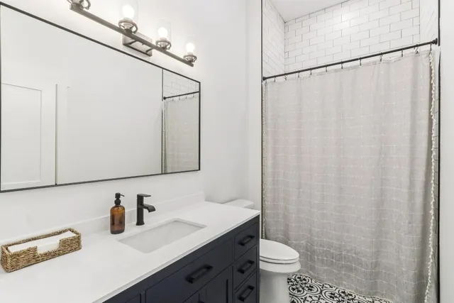 a bathroom with a sink vanity mirror and toilet