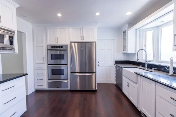a kitchen with stainless steel appliances a refrigerator sink and cabinets