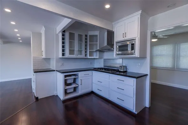 a kitchen with stainless steel appliances granite countertop a stove a sink and a microwave