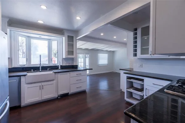 a large kitchen with granite countertop a stove and a sink