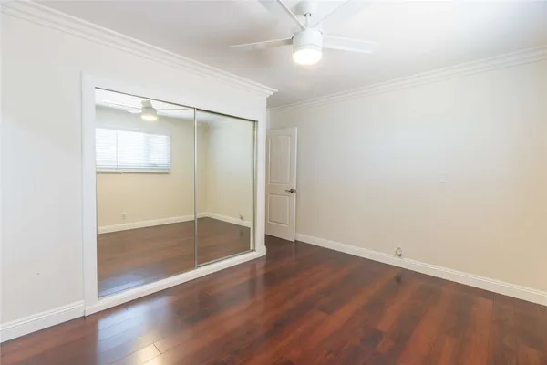 an empty room with wooden floor and mirror