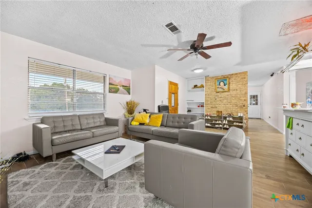 a living room with furniture ceiling fan and a window