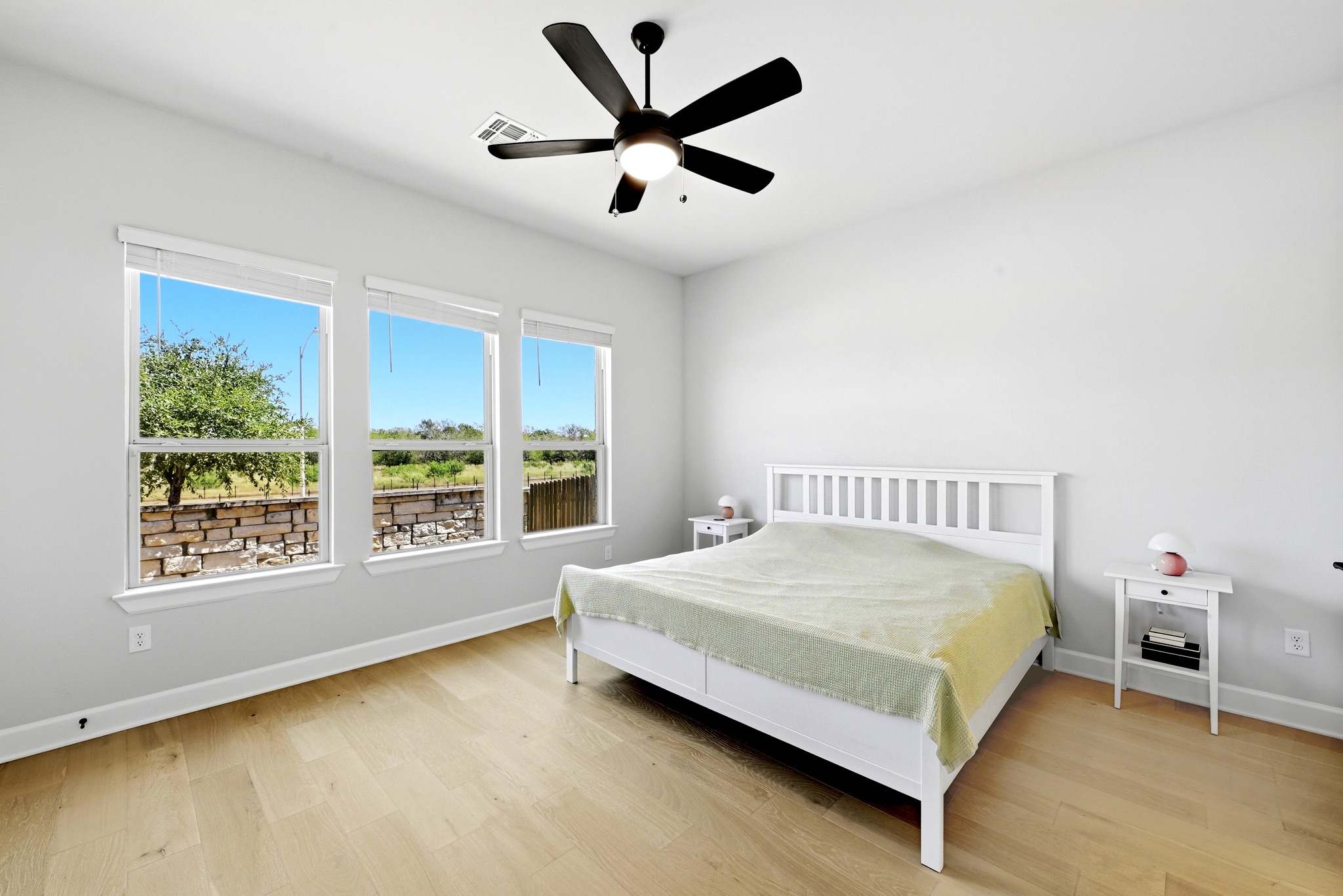 2702 Sebring Circle Austin, TX 78747 - Photo 13 of 35 Generous windows frame outdoor views in this bedroom featuring hardwood floors.