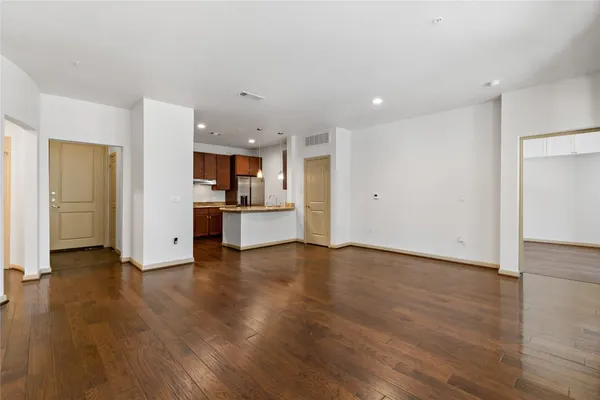 a view of a kitchen island a sink wooden floor and a living room