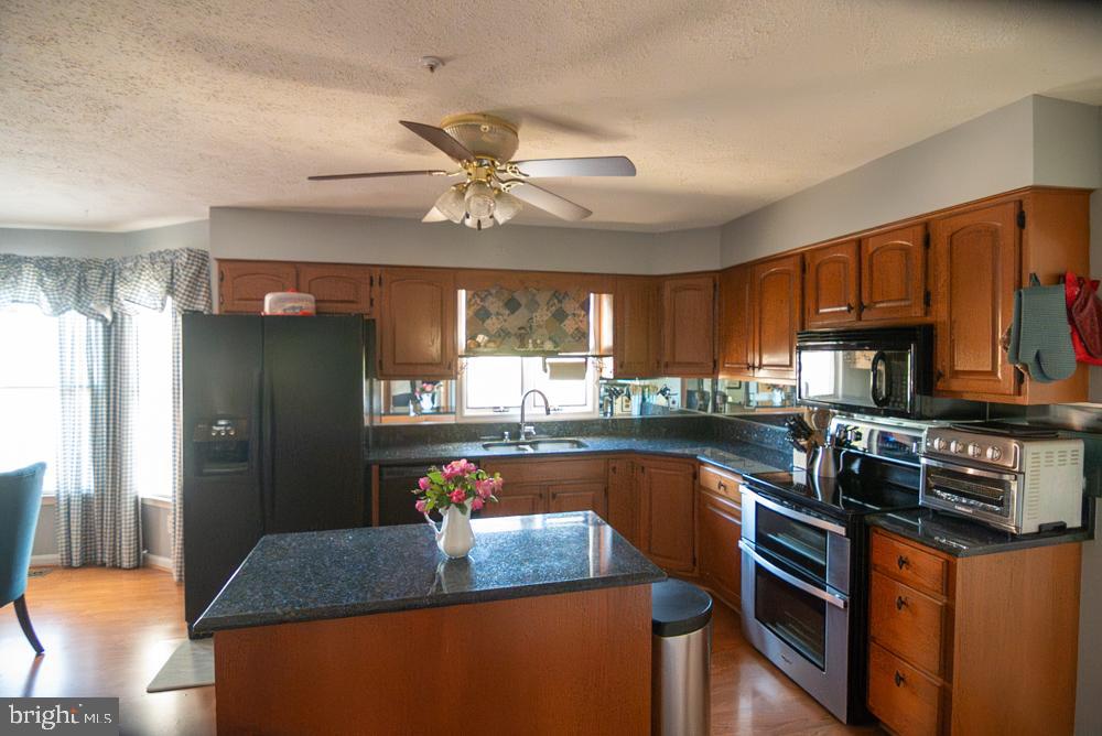 15900 Bald Eagle School Road Brandywine, MD 20613 - Photo 16 of 33 a kitchen with stainless steel appliances granite countertop a refrigerator a sink dishwasher a stove and white countertops with wooden floor