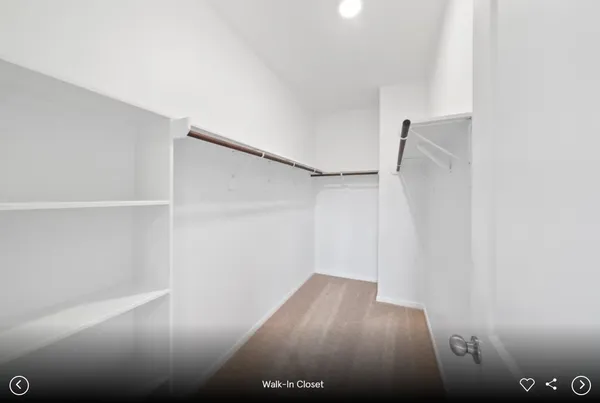 a view of walk in closet with wooden floor