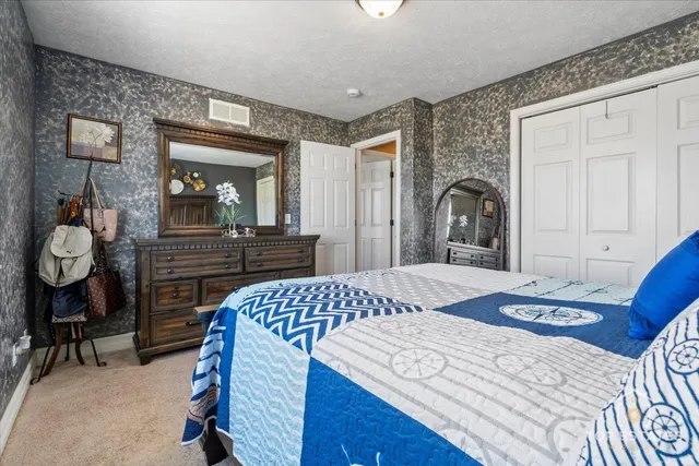 a bedroom with a bed and dresser with mirror