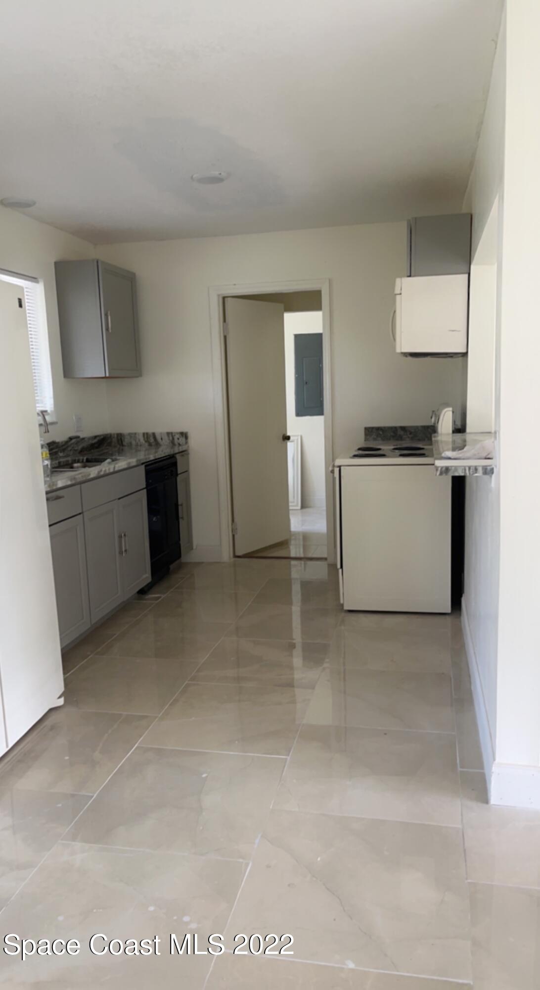 219 Eldron Boulevard Southeast Palm Bay, FL 32909 - Photo 4 of 9 a large kitchen with cabinets and stainless steel appliances