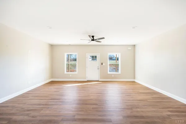 a view of a kitchen with wooden floor and a ceiling fan