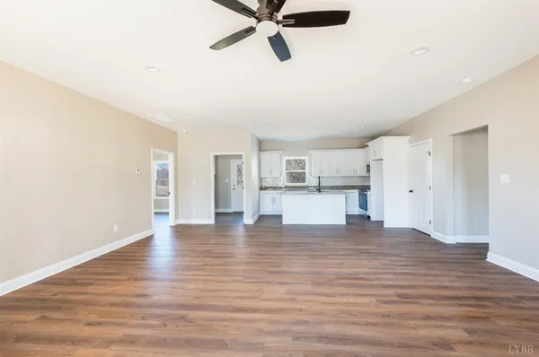 a view of a kitchen with wooden floor and a kitchen space