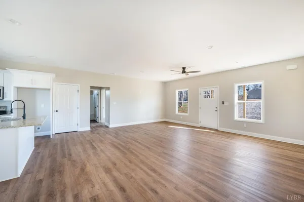 a large kitchen with a wooden floor and white cabinets