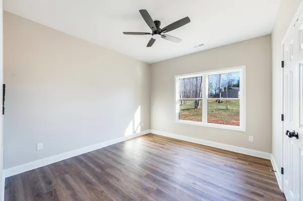a view of a hallway with wooden floor and a living room