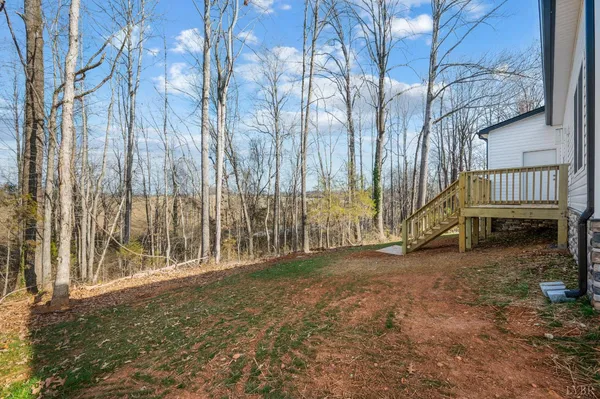 a view of outdoor space with wooden fence and large trees