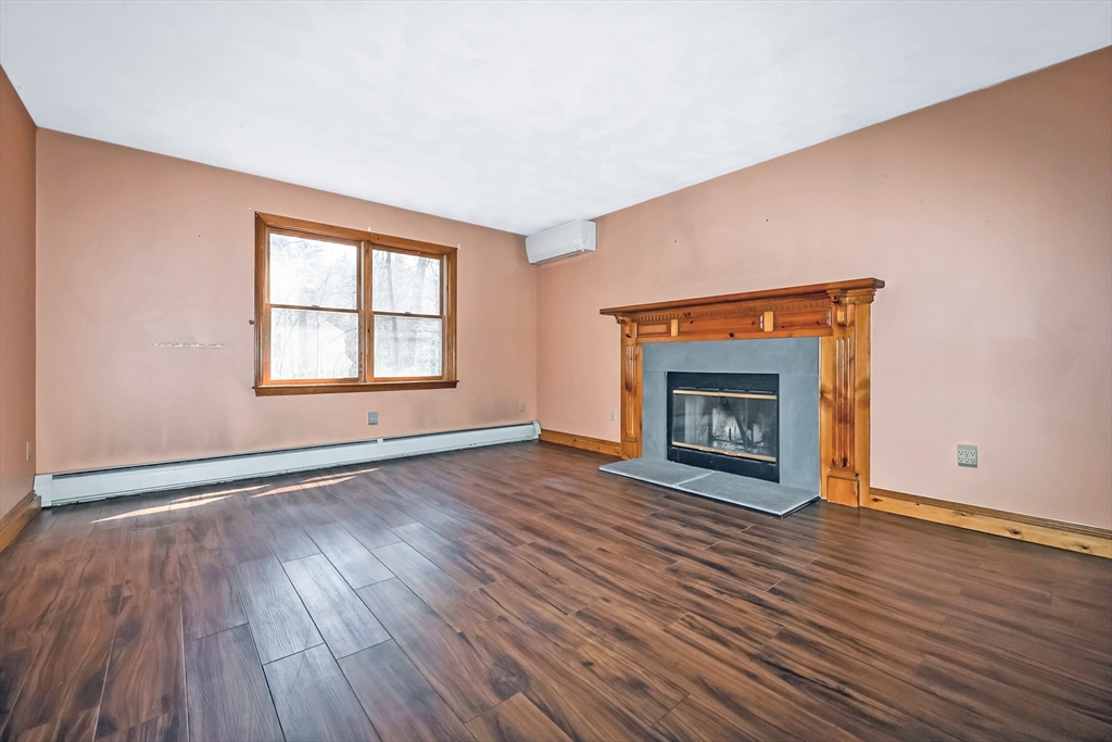 6 Ryan Road Townsend, MA 01474 - Photo 17 of 41 an empty room with wooden floor fireplace and windows