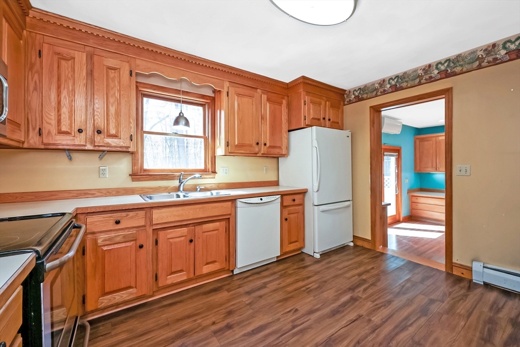 6 Ryan Road Townsend, MA 01474 - Photo 5 of 41 a kitchen with stainless steel appliances granite countertop a refrigerator a sink dishwasher and wooden cabinets with wooden floor