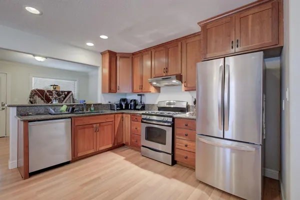 a kitchen with stainless steel appliances granite countertop a refrigerator sink and cabinets
