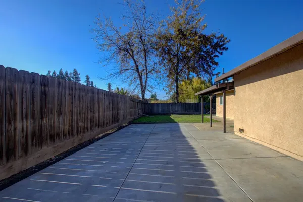 a view of backyard with wooden fence