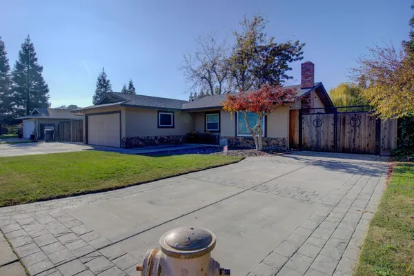 a front view of a house with a yard and potted plants