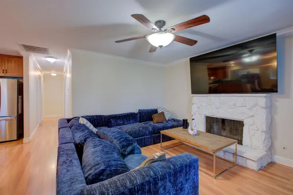a living room with furniture a flat screen tv and a fireplace