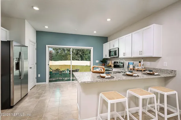 a kitchen with stainless steel appliances granite countertop a stove top oven a sink dishwasher a refrigerator and a microwave