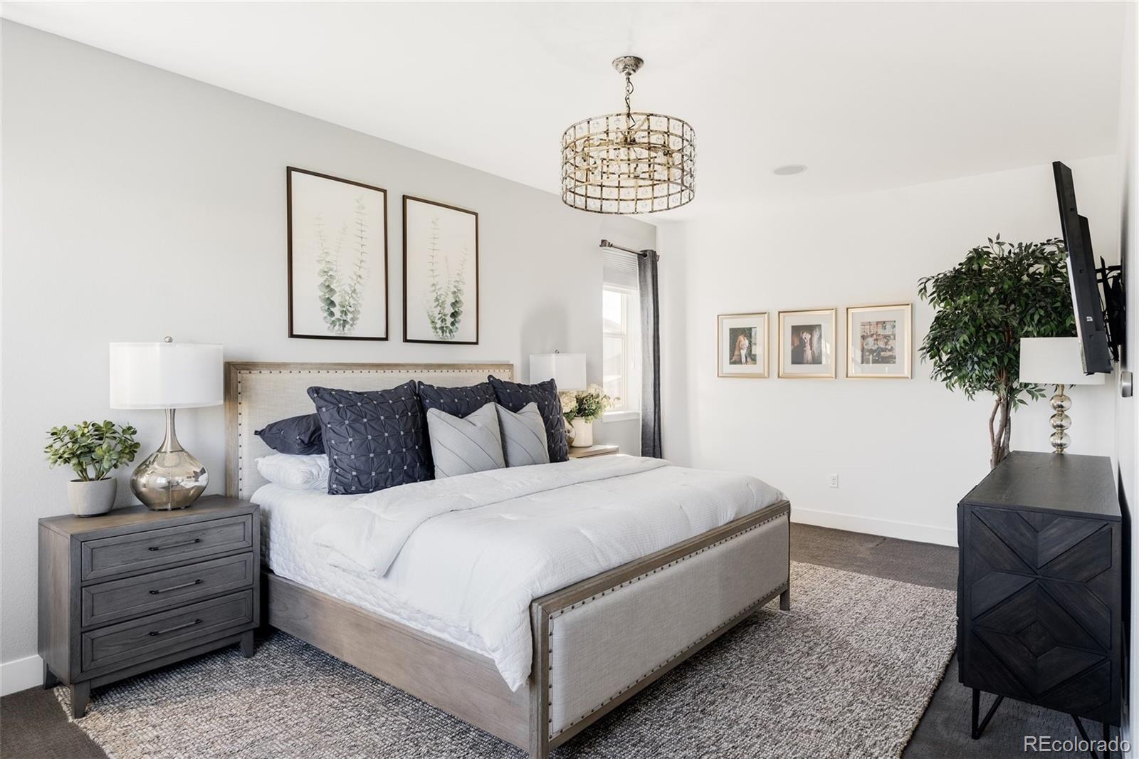 7790 East 32nd Avenue Denver, CO 80238 - Photo 16 of 40 a bedroom with a bed and a chandelier