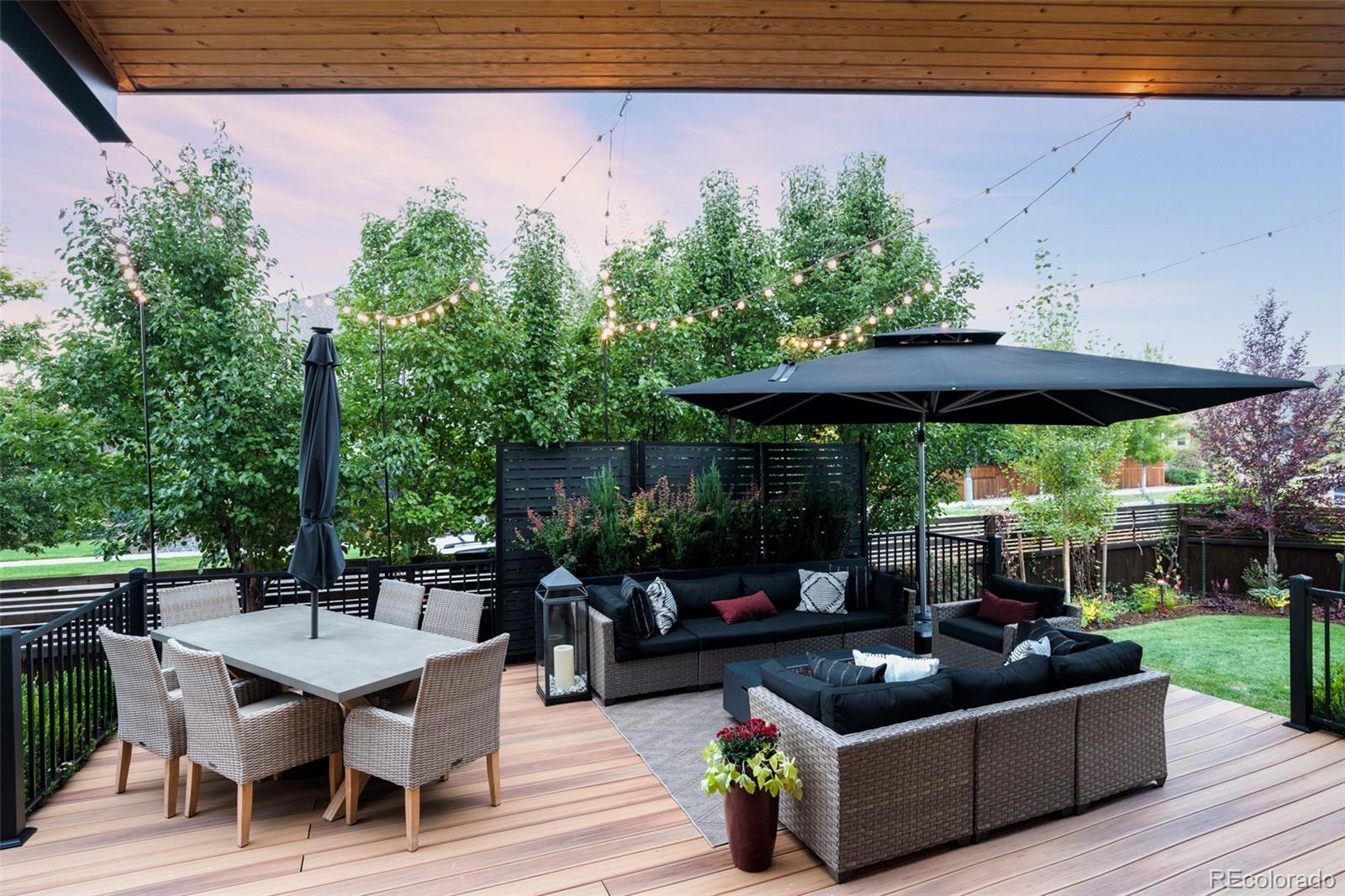 7790 East 32nd Avenue Denver, CO 80238 - Photo 38 of 40 a view of a patio with couches table and chairs under an umbrella with a small yard