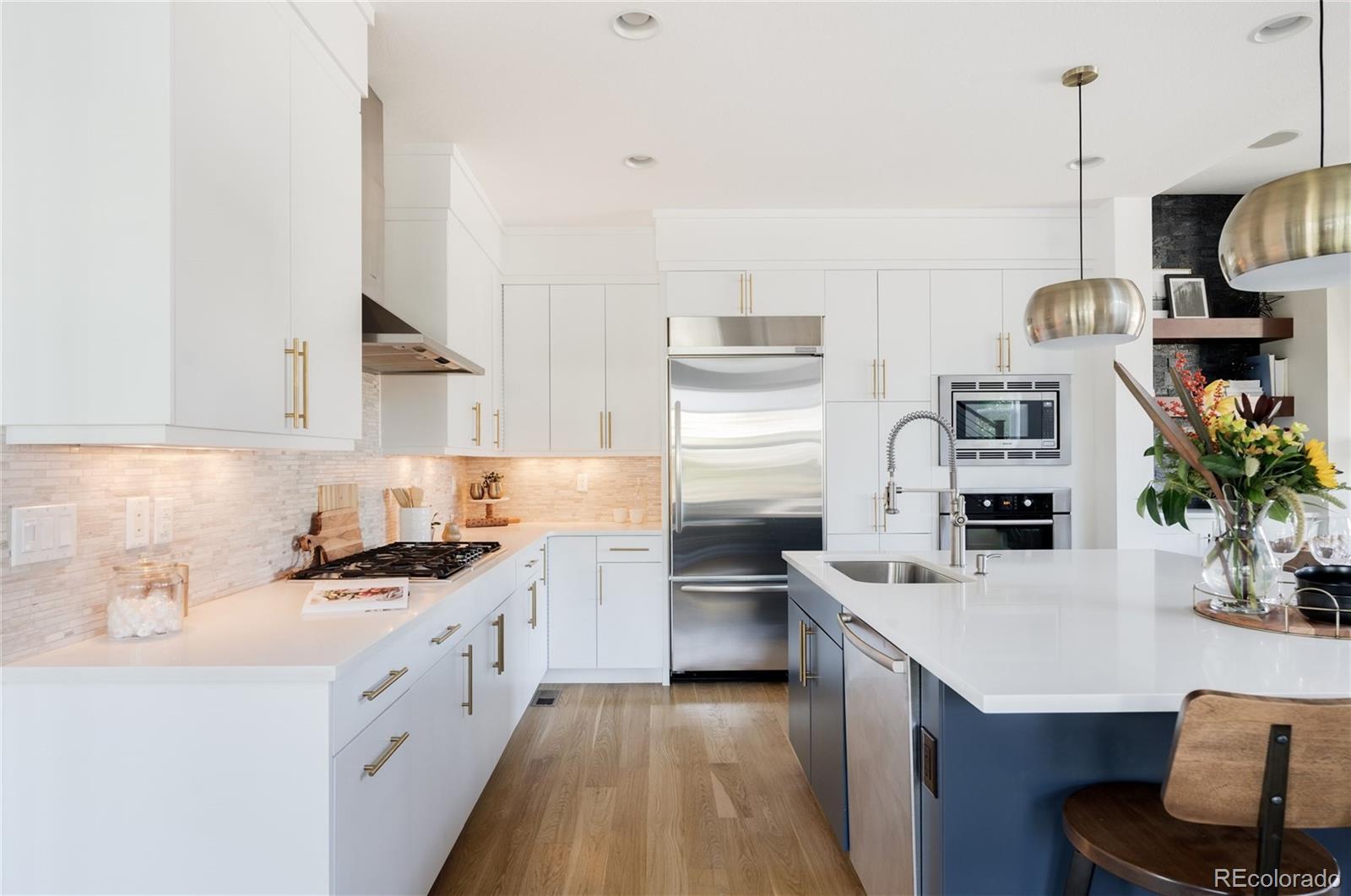 7790 East 32nd Avenue Denver, CO 80238 - Photo 7 of 40 a kitchen with stainless steel appliances a stove sink microwave and cabinets