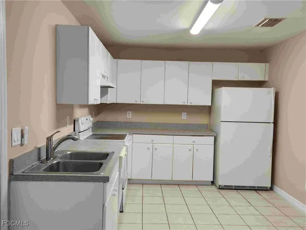 a kitchen with a sink a refrigerator and cabinets
