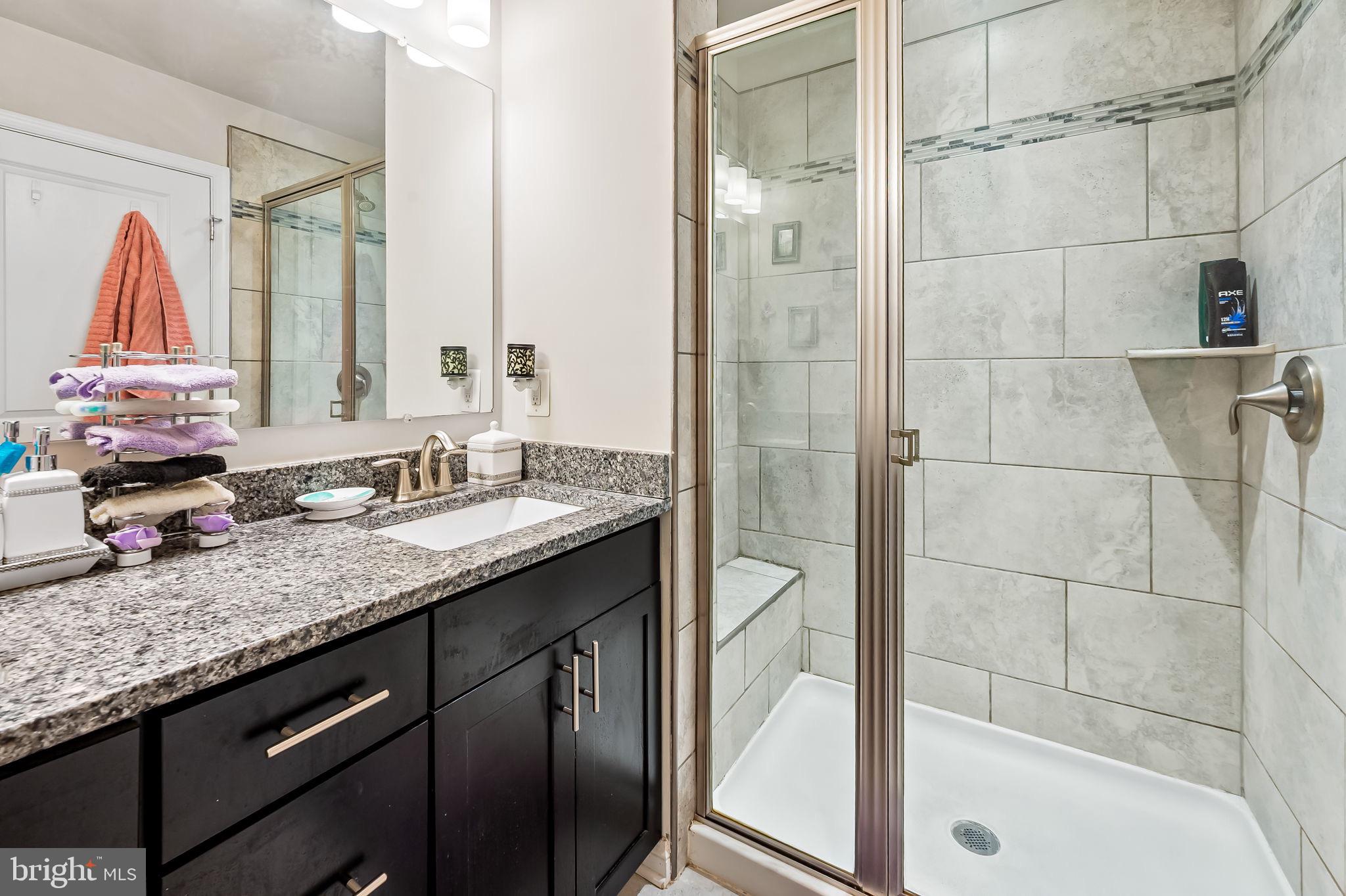 1309 Spindrift Road Aberdeen, MD 21001 - Photo 24 of 35 a bathroom with a granite countertop sink a mirror and a bathtub