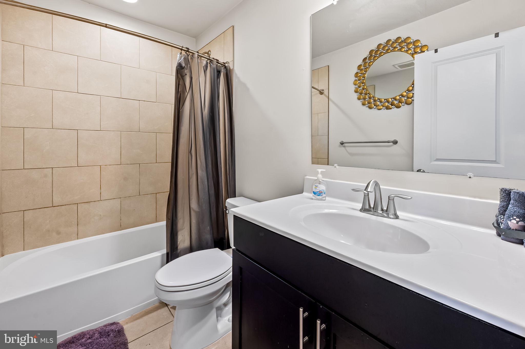 1309 Spindrift Road Aberdeen, MD 21001 - Photo 29 of 35 a bathroom with a sink a toilet a mirror and shower