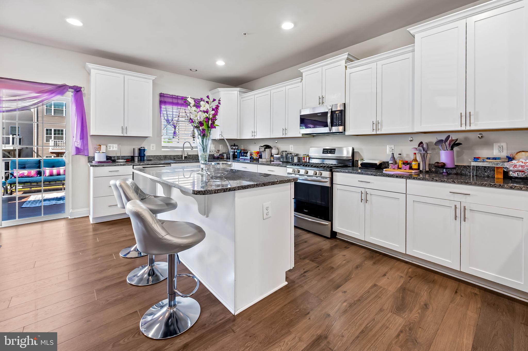 1309 Spindrift Road Aberdeen, MD 21001 - Photo 6 of 35 a kitchen with stainless steel appliances granite countertop a stove a sink dishwasher and white cabinets with wooden floor