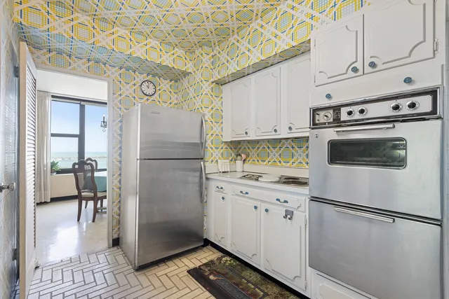a white refrigerator freezer and a stove sitting inside of a kitchen