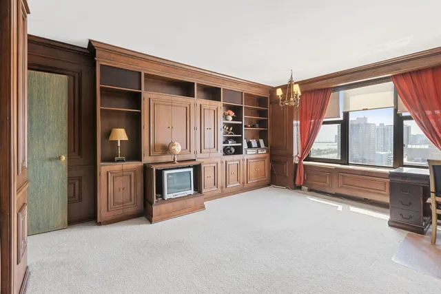 a living room with stainless steel appliances furniture and a large window